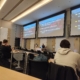 A lecture hall with students facing a presentation screen displaying bullet points about setting goals and determining personal values.